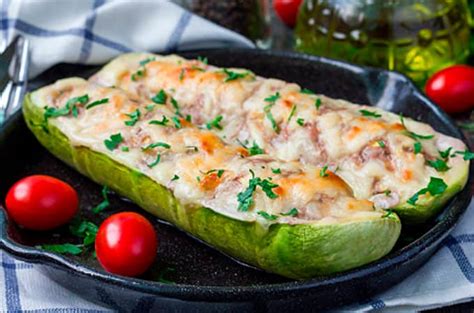 Zapallitos italianos cortados por la mitad y ahuecados, listos para hornear, en una fuente de horno