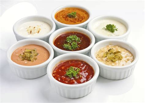 Foto de diferentes tipos de salsas para untar a base de mayonesa en pequeños cuencos.