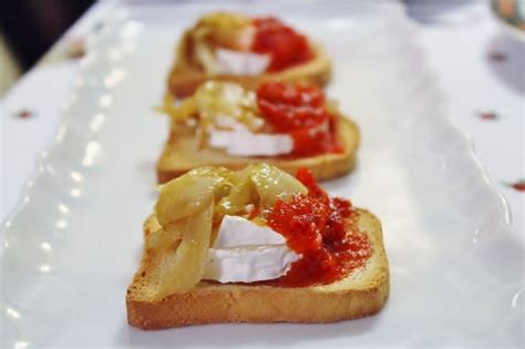 Plato de tostas con queso de cabra y mermelada de pimientos verdes.