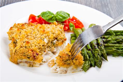 Pescado gratinado en fuente de horno, recién salido, con una capa dorada y burbujeante.