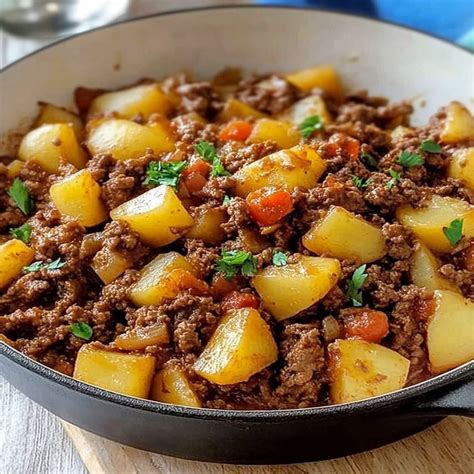 Plato de guisado de espinacas con carne molida y papas salteadas