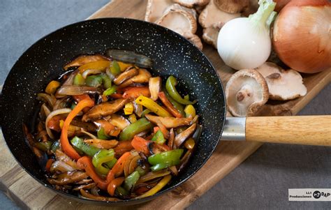 foto de un wok en pleno proceso de salteado de fideos de arroz con verduras