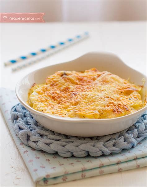 Fotografía de un plato con patatas gratinadas junto a una generosa porción de salsa de champiñones