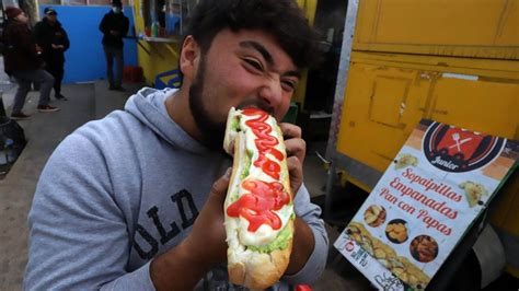 Personas comiendo completos en un local tradicional chileno