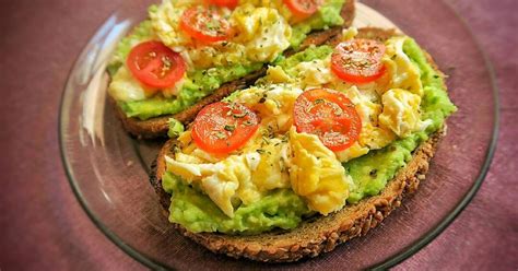 Tostada de aguacate y huevo lista para servir, con una taza de café al lado
