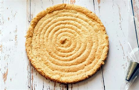 Esquema visual de las capas: base de bizcocho dacquoise, relleno de crema muselina al praliné y capa superior de dacquoise con azúcar glas.