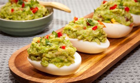 Huevos rellenos de guacamole decorados con cilantro