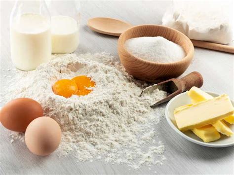 Ingredientes básicos para repostería: huevos, leche, mantequilla, harina, azúcar en un entorno de cocina