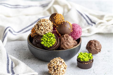 Variedad de trufas de chocolate y pequeños dulces en un plato