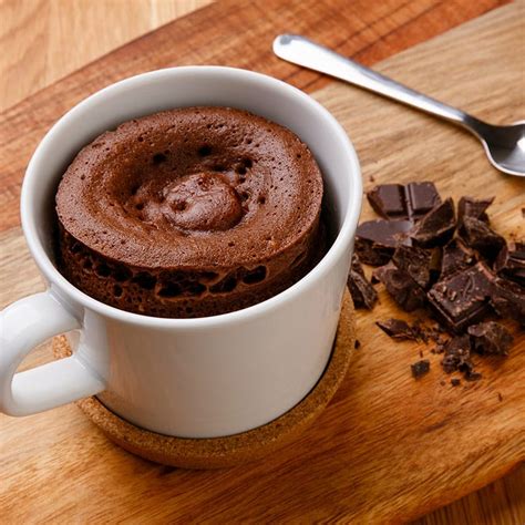 Mug cake de chocolate en una taza y una mousse de frutas en un vaso