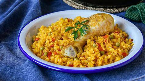 Arroz amarillo con pollo y verduras en una paellera