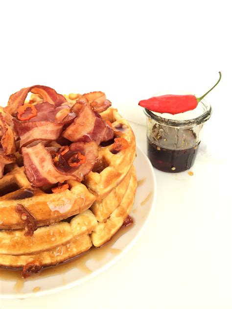 Plato de waffles caseros con jarabe de maple, tocino y ají