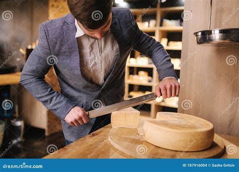 hombre cortando un queso curado casero