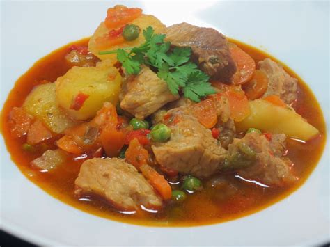 Ingredientes frescos para estofado: lomo de cerdo, zanahorias, papas, cebolla, pimentón