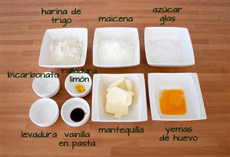 Mesa de cocina con ingredientes para alfajores: fécula de maíz, harina, mantequilla, huevos, etc.