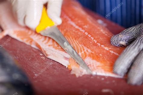 Imagen de manos retirando espinas de un filete con pinzas