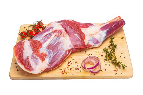 Pierna de cordero cruda con cortes superficiales, lista para marinar.