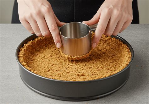 Primer plano de una base de galletas siendo presionada en un molde desmontable