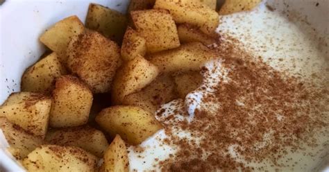 Un bowl de yogur natural con trozos de manzana fresca y canela espolvoreada