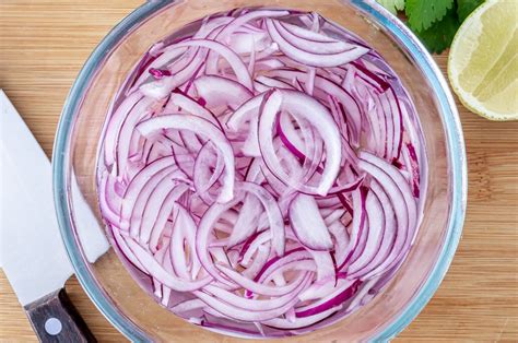 Una selección de ingredientes frescos para ceviche: limones, cebolla morada, cilantro y pimentón.