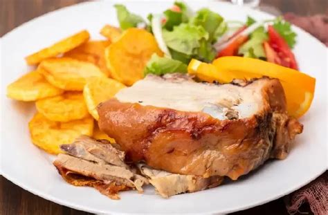 Chancho al horno con piel crocante servido en una mesa festiva