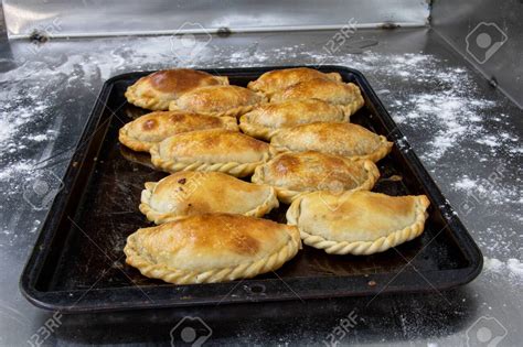 Foto de una bandeja de empanadas de horno doradas y recién hechas