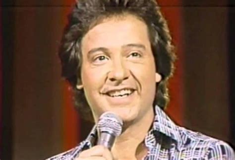 Retrato de Pollo Fuentes sonriendo, con un fondo musical o televisivo