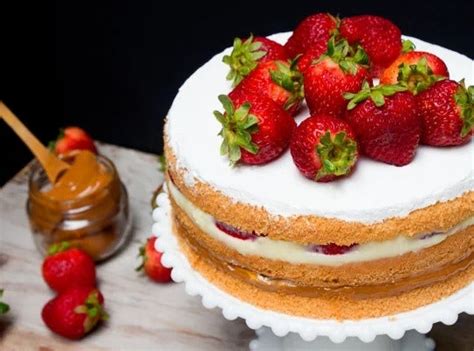 Montaje de pastel con capas de bizcocho, manjar y fresas