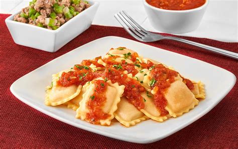 Plato de ravioles con salsa de carne y queso rallado