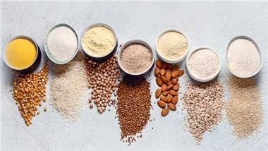 Mesa con diferentes tipos de harinas alternativas y saludables: almendra, coco, garbanzo, avena y variedades integrales.