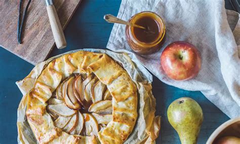 Primer plano de láminas finas de manzana dispuestas sobre la masa de tarta.
