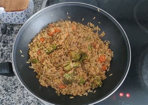 Sartén tipo wok con arroz mezclándose con salsa de soja y vegetales
