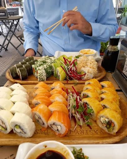 Fotografía de un surtido de platos de Quimey Fusion & Gluten Free Viña, incluyendo sushi, hamburguesas y un plato principal, todos etiquetados como sin gluten.