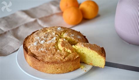 Imagen de un bizcocho de naranja y amapolas recién horneado, con una rebanada cortada para mostrar la textura interior.