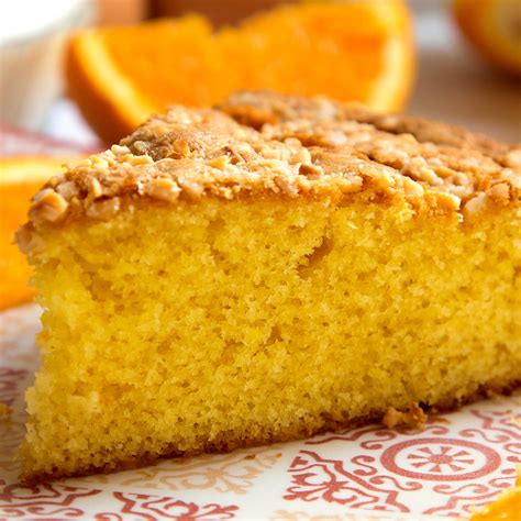Foto de un bizcocho de avena con naranja y amapolas servido con un chorrito de sirope de arce.
