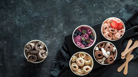 Foto de helado tailandés recién enrollado con toppings en un cuenco.