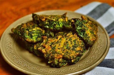 Plato de fritos de acelga recién hechos con guarniciones variadas a su alrededor