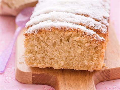 Bizcocho de coco y maicena recién horneado, espolvoreado con coco rallado, sobre una rejilla