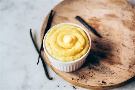 Recipiente con crema pastelera vegana enfriándose, cubierta con film transparente para evitar costra.