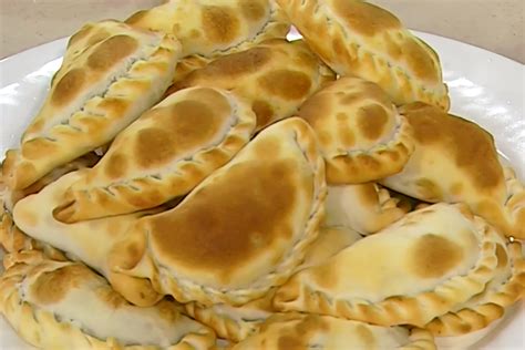 Una variedad de empanadas horneadas y fritas, mostrando diferentes formas y tamaños.