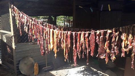 fotografía de piezas de cecina secándose en un ambiente rústico con aire de montaña