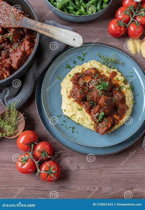 Estofado de carne humeante servido con polenta cremosa en un plato
