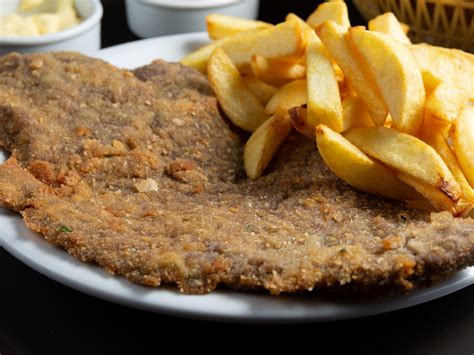 Plato de milanesas de carne con avena acompañadas de una guarnición fresca