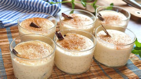 Fotografía de un arroz con leche cremoso servido en copas con canela espolvoreada.