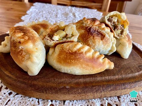 Primer plano de empanadas salteñas de carne, cebolla y pimiento, con repulgue tradicional
