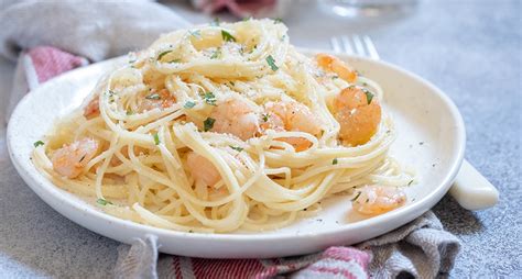 Fotografía gastronómica de un plato de espaguetis con camarones y salsa cremosa