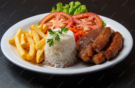Variedad de acompañamientos: arroz blanco, papas fritas y una ensalada fresca.