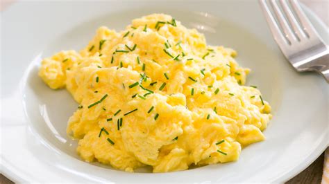 Huevos revueltos o tortilla con ciboulette picado por encima, servido en un plato