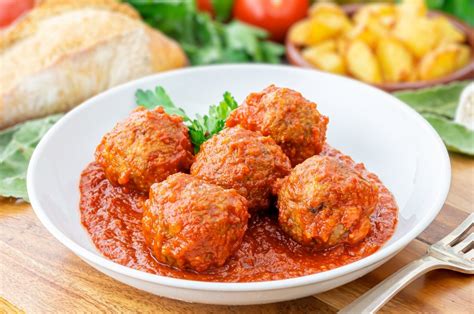 Plato de mini albóndigas de pavo en salsa de tomate, decorado con albahaca fresca