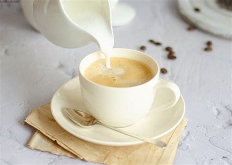 Taza de café con leche condensada con sus ingredientes al lado, destacando su dulzura y cremosidad